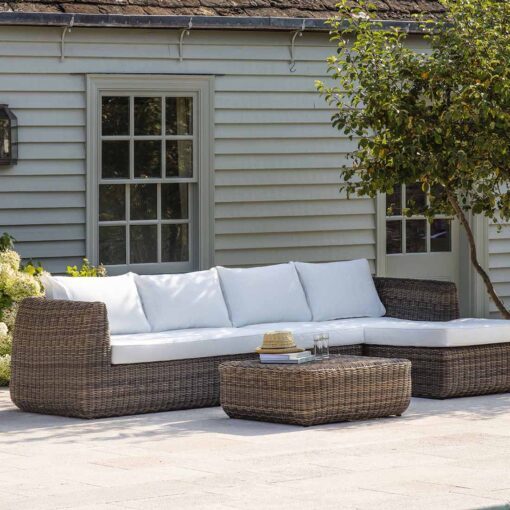 large brown rattan sofa set with chaise longue and footstool complete with off-white cushions