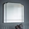 large overmantle mirror with a think charcoal black metal frame, elegantly curved top and panelled detailing