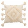 large cream cushion with a textured tufted diamond pattern and large pom pom edges