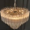 large art deco style twelve pendant chandelier with layers of clear glass ribbed glass tubes suspended from a silver steel frame and adjustable chain
