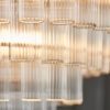 large art deco style twelve pendant chandelier with layers of clear glass ribbed glass tubes suspended from a silver steel frame and adjustable chain