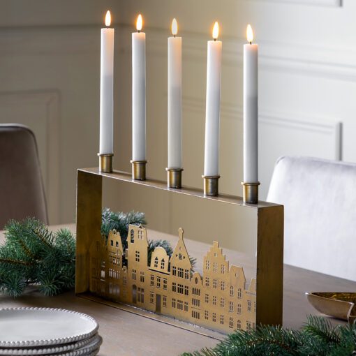 large gold metal rectangular five candle holder with a central cut-out townhouse design