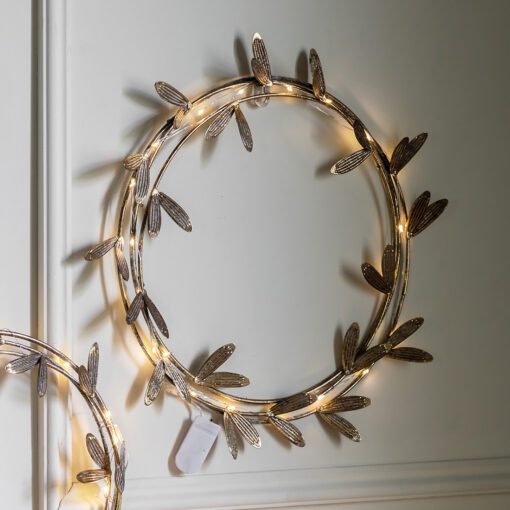 round metal mistletoe wreath with an antique gold finish and warm white led lights