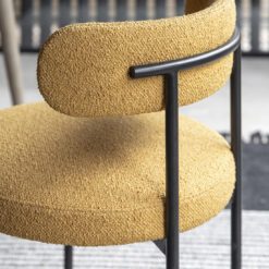 set of two contemporary round dining chairs upholstered in a textured ochre fabric with a curved back and black metal frame