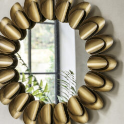 decorative round metal wall mirror with a wide frame made up of two layers of large petal shapes finished in a warming bronze metallic