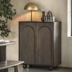 two door wood cubpoard with relief arch design, large ball feet and dark walnut stained finish