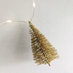 wire warm-white LED light garland interspersed with gold brush trees dusted in gold glitter
