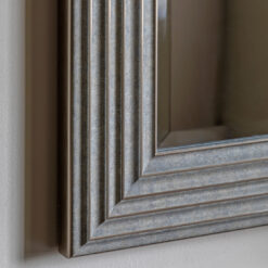 decorative square wall mirror with a stepped ribbed wide frame and distressed silver finish