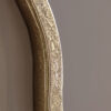 decorative round wall mirror with a wavy silm metal frame finished in gold leaf