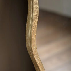 decorative full length leaner mirror with a wavy silm metal frame finished in gold leaf