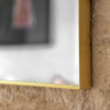 large arched overmantle wall mirror with a slim metal frame finished in warming gold