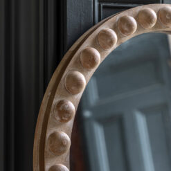 arched full length wooden mirror with a natural white-wash finish and a bold bobble design to the frame