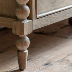 oak seven drawer chest with elegant bobbin corner detailing, a subtle lime wash and small round knobs