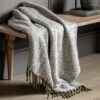 faux mohair throw with a herringbone patter and long fringing in olive green