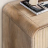 two drawer mango wood console table with a curved silhouette, fluted drawer fronts with brass handles and lower shelf