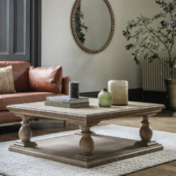 chunky square wooden coffee table with turned pillar legs and bottom shelf