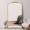 oversized large wall mirror with a decorative slim frame, arched top and ornate crown finished in a warm gold