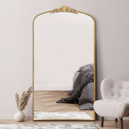 oversized large wall mirror with a decorative slim frame, arched top and ornate crown finished in a warm gold