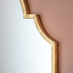 elegant wall mirror with a curved crown detailing and and warm gold slim metal frame
