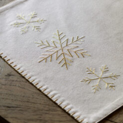 natural cream christmas table runner with gold embroidered snowflakes and blanket stitch edging
