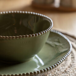 set of four porcelain bowls with an uneven round shaping, beaded edging and glossy olive green glaze