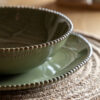 set of four porcelain pasta bowls with an uneven round shaping, beaded edging and glossy olive green glaze