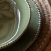 set of four porcelain pasta bowls with an uneven round shaping, beaded edging and glossy olive green glaze