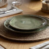 set of four porcelain side plates with an uneven round shaping, beaded edging and glossy olive green glaze