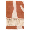 cosy chenille throw with a warm sienna and cream abstract patter and long, soft cream tassel edging