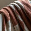 cosy chenille throw with a warm sienna and cream abstract patter and long, soft cream tassel edging