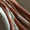 cosy chenille throw with a warm sienna and cream abstract patter and long, soft cream tassel edging